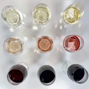 Ocho copas de vino de diferentes colores, mostrando la diversidad de vinos, incluyendo blancos, rosados y tintos.